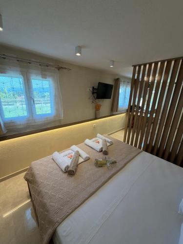 a bedroom with a bed with towels and a tv at MANDARIN Luxury Suites in Asprovalta