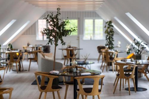 ein Restaurant mit Tischen und Stühlen in einem Raum in der Unterkunft Allinge Badehotel in Allinge