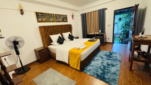 a bedroom with a bed and a desk with a fan at Restora Ella in Ella