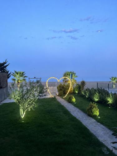 a garden with a arch and lights in the grass at NOVA PORT Boutique Hotel in Tekirdağ