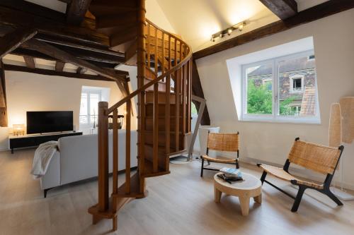 a living room with a spiral staircase and chairs at Le JOLIE DUPLEX in Colmar