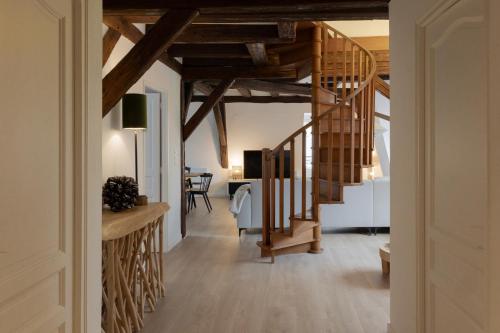 a hallway with a spiral staircase in a home with wooden ceilings at Le JOLIE DUPLEX in Colmar