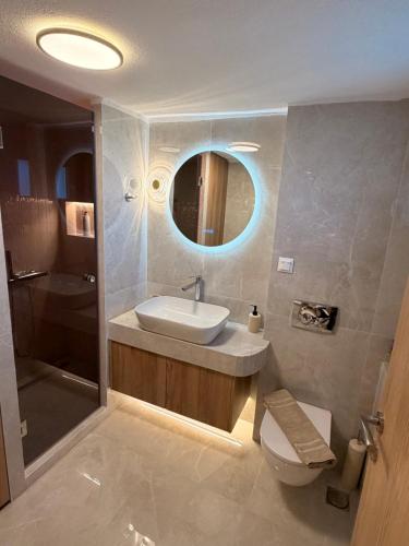 a bathroom with a sink and a toilet and a mirror at MANDARIN Luxury Suites in Asprovalta
