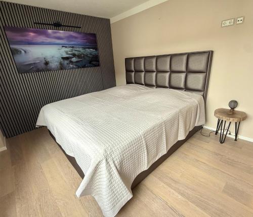 a bedroom with a bed with a white bedspread at Sassnitz - Modernisiert 2026 - Outdoor Teich, Spa-Sauna, Fitness, Kamin - FeWo Fontane in Sassnitz