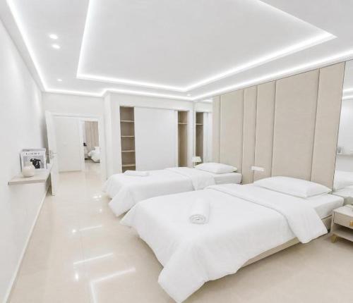 a white room with four beds in it at Al Hoceima Luxury Residence Amina 3 in Al Hoceïma