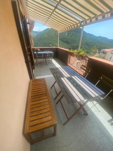 a balcony with a wooden bench and a table at La terrazza nel borgo in Tortora