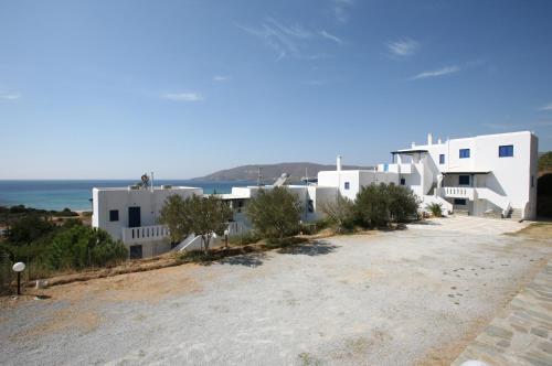 a group of white buildings with the ocean in the background at Villa Maniati Studios in ayios Petros