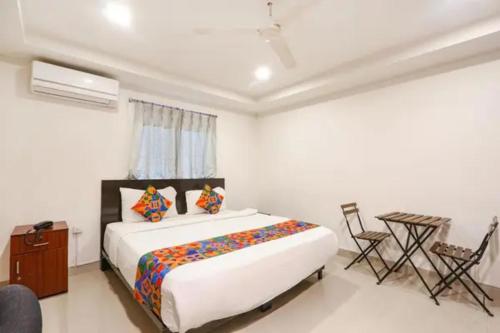 a bedroom with a bed and a table and chairs at FabHotel Blue Dawn Gachibowli in Gachibowli