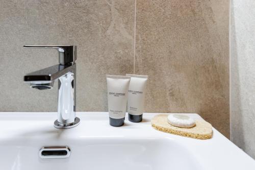 a bathroom sink with two cups sitting on it at Appartamento Petit Flower in Valdidentro