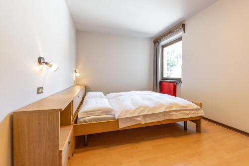 a bedroom with a bed and a desk at Appartamento Petit Flower in Valdidentro