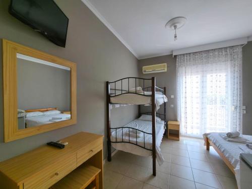 a room with two bunk beds and a mirror at Europa Hotel Korinos in Korinos