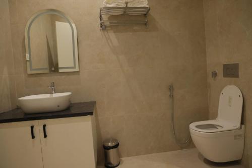 a bathroom with a sink and a toilet and a mirror at MOKSH SERENe in Shrīnagar