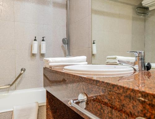 a bathroom with a sink and a tub and a mirror at Mirador del Cabo Designed For Adults in Aguadulce