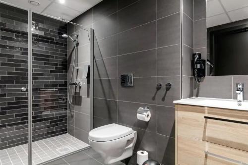 a bathroom with a shower and a toilet and a sink at Skistar Lodge Hemsedal in Hemsedal