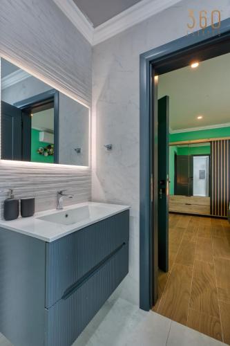 a bathroom with a sink and a mirror at Central Malta Gem - 3BR Apartment with Balconies in Mosta