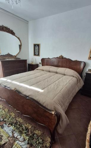 Casa Vacanze CIMMO في Tavernole sul Mella: غرفة نوم بها سرير كبير ذو إطار خشبي