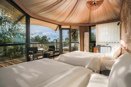 a bedroom with two beds and a large window at Seawind Cloudcrest Resort in Semporna