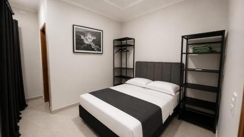 a bedroom with a bed and shelves in it at Apto central ideal para casais e famílias em Foz 3 in Foz do Iguaçu
