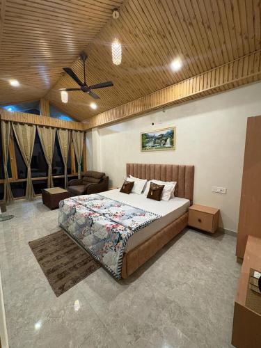a bedroom with a large bed and a couch at Tulip Flowing River View Hotel. in Shamshi