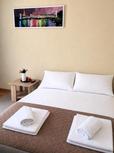a bedroom with two beds and a table with towels at Urban Retreat in Osijek