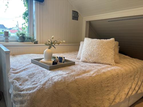 a bedroom with a large bed with a vase on it at Loftsrom in Drammen