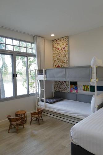 a bedroom with two bunk beds and two chairs at Mazecape in Ban Hua Khwai