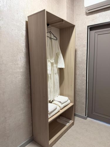 a wooden wardrobe with towels and a shirt in it at AiTumar boutique hotel in Almaty