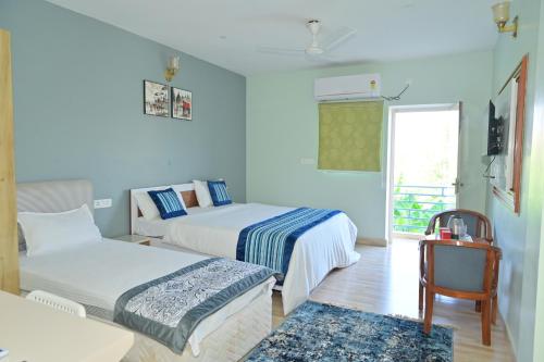 a hotel room with two beds and a chair at shangrila stay in Bodh Gaya