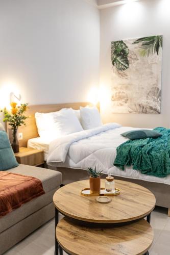 a hotel room with two beds and a coffee table at Breeze Apartments Megara - Echo in Megara