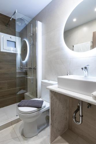 a bathroom with a toilet and a sink and a shower at Breeze Apartments Megara - Echo in Megara