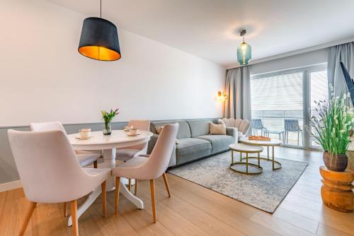 a living room with a couch and a table and chairs at Happy Land Aqua Polanki B405 in Kołobrzeg