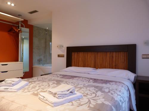a bedroom with a large bed with towels on it at Puerta de Ordesa Garden in Laspuña