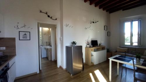 ein Wohnzimmer mit Kühlschrank und Tisch in der Unterkunft Camillo Benso in Bernareggio