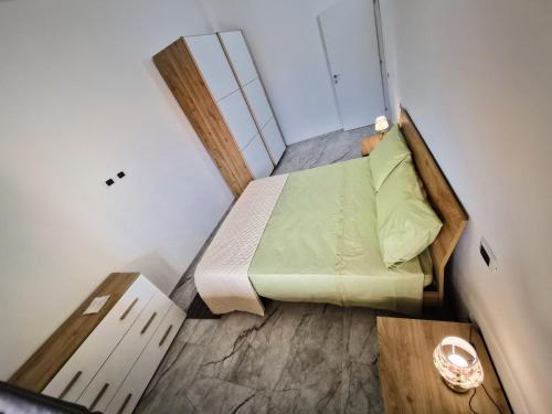 a small bedroom with a bed and a mirror at House Manu in Assemini