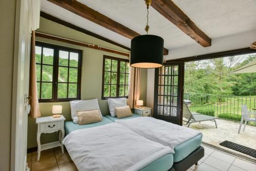a bedroom with a large bed and a balcony at Font Neuve in Souillac