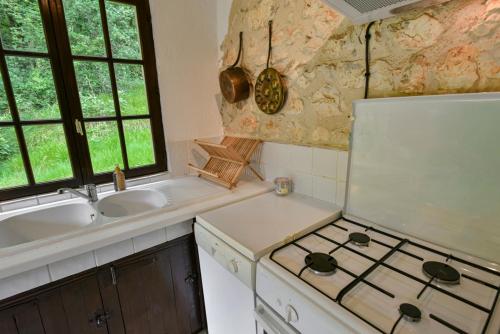 a kitchen with a sink and a stove top oven at Font Neuve in Souillac