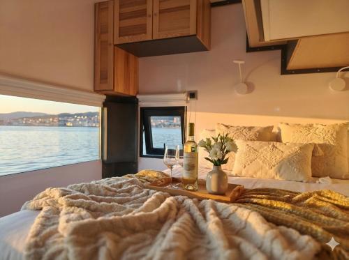 a bedroom with a bed with two glasses of wine at Barco Different Charter - Experiencia Única en el Puerto Deportivo de Vigo in Vigo
