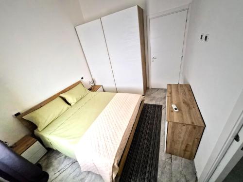 a small bedroom with a bed and a wooden table at House Manu in Assemini