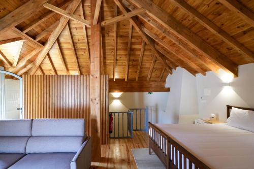 a bedroom with a large bed and a couch at Feel Discovery Casa da Aldeia in Mós