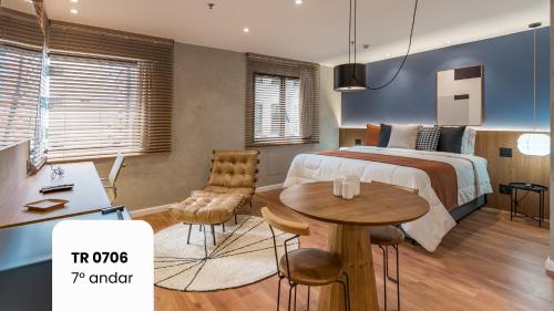 a bedroom with a bed and a table and chairs at Cyclinn Faria Lima Itaim in São Paulo