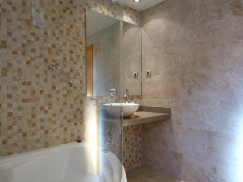 a bathroom with a sink and a tub and a sink at Puerta de Ordesa Garden in Laspuña