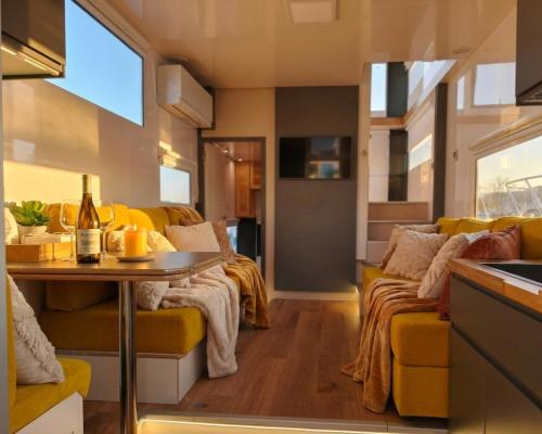 a living room with a yellow couch and a table at Barco Different Charter - Experiencia Única en el Puerto Deportivo de Vigo in Vigo