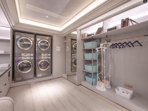 a laundry room with three washing machines in it at Mercure Xi'an High-tech Zone Center in Xi'an