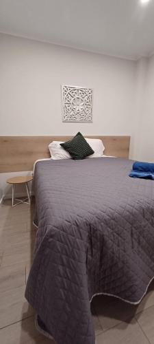 a bedroom with a large bed with a gray blanket at Villa Ti Neves - Peniche Beach Residence in Peniche