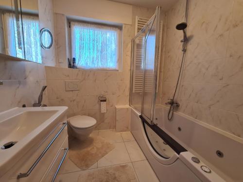a bathroom with a tub and a toilet and a sink at Family Suites & Parking in Baden-Baden