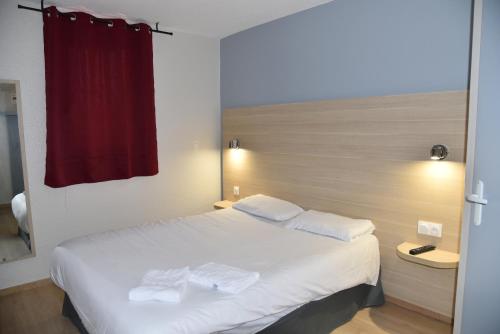 a bedroom with a white bed with two towels on it at FastHotel Thionville in Thionville