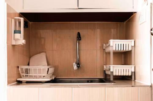 a kitchen with a sink and two baskets on the wall at Cozy 1br walk to BTS and Airport Rail Link Close to Malls T in Bangkok