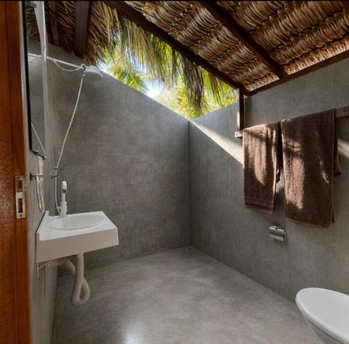 a bathroom with a sink and a toilet in it at ArpoadorBangalôparaísoperdido in Tutóia