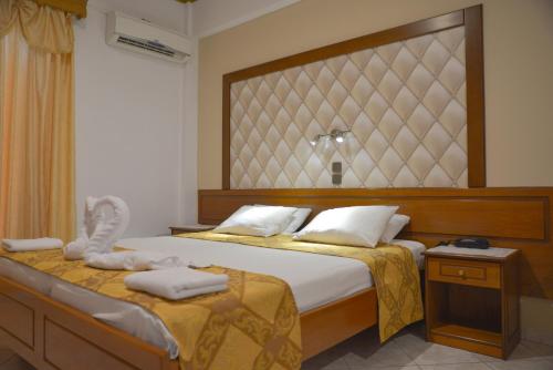 a bedroom with a large bed with towels on it at Angelina Hotel & Apartments in Sidari