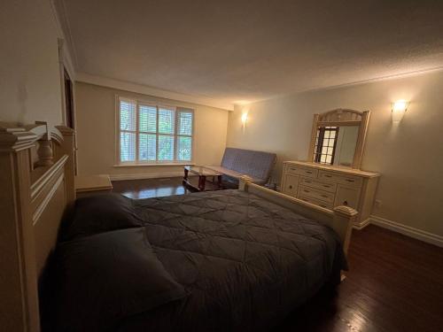 a bedroom with a bed and a dresser and a mirror at House in Markham in Markham